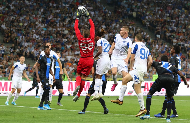 A soccer player jumps to block a ball in the Belgian Jupiler Pro League