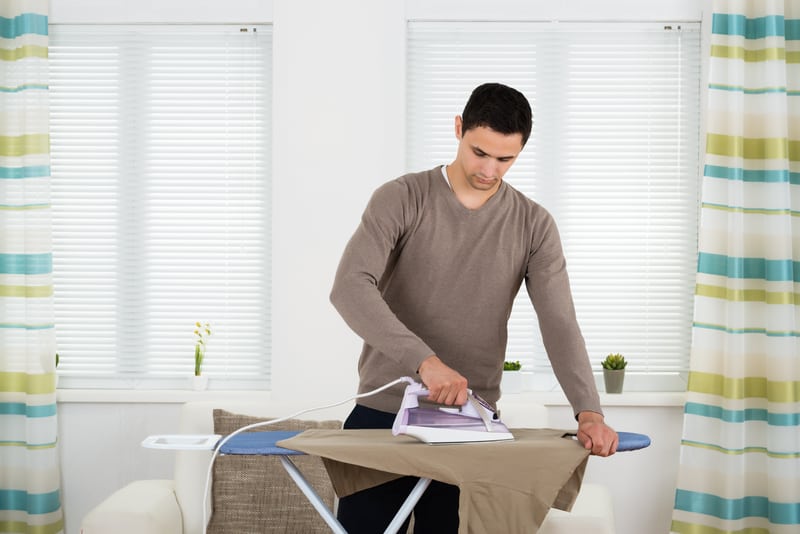 Using an iron to stretch a soccer jersey.